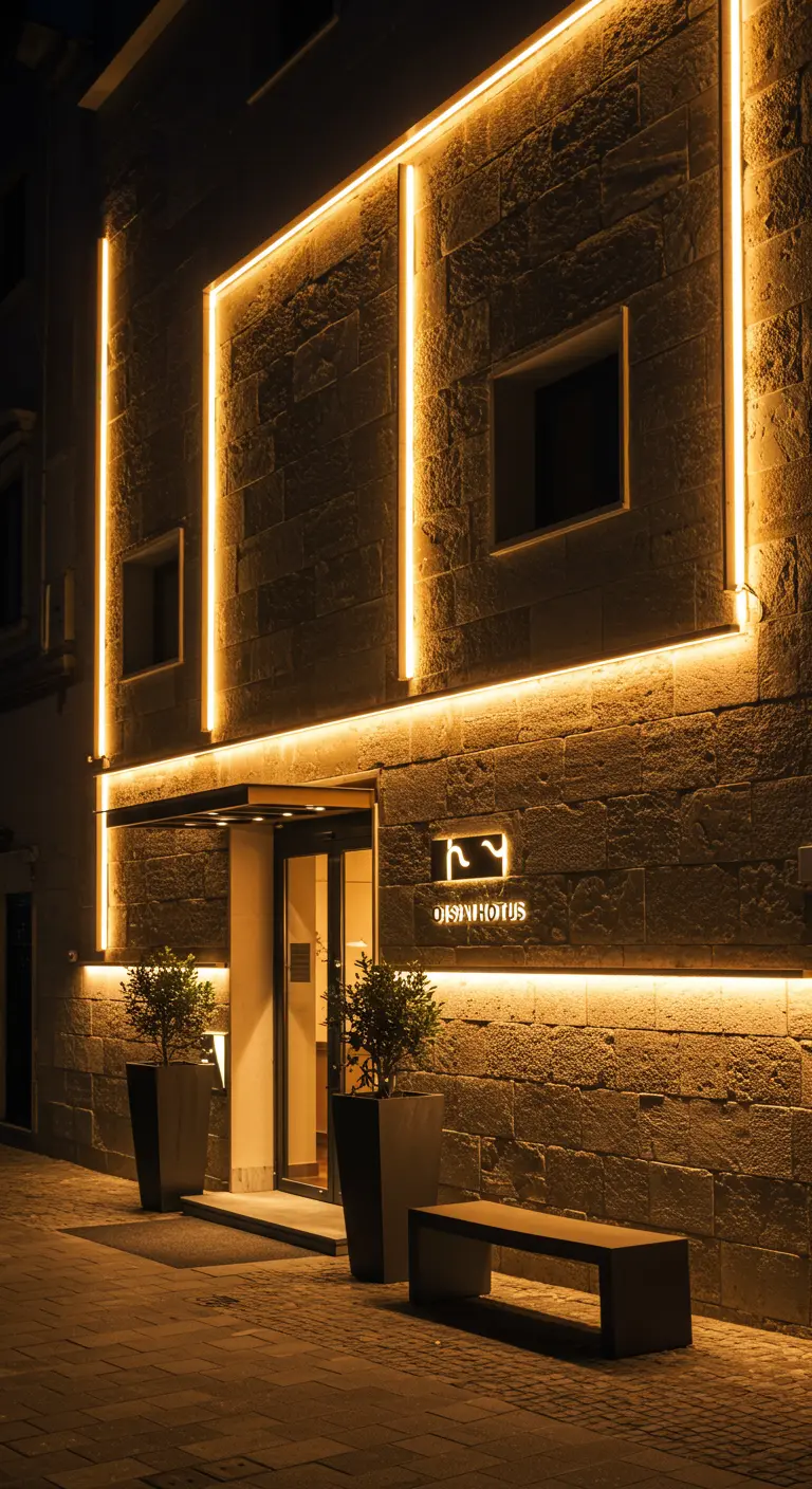 Façade de maison rustique en pierre avec un porche éclairé par des guirlandes lumineuses.