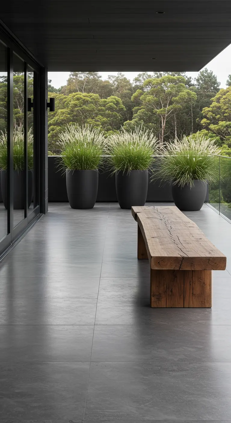 Balcon minimaliste avec un banc en bois brut et trois grands pots noirs