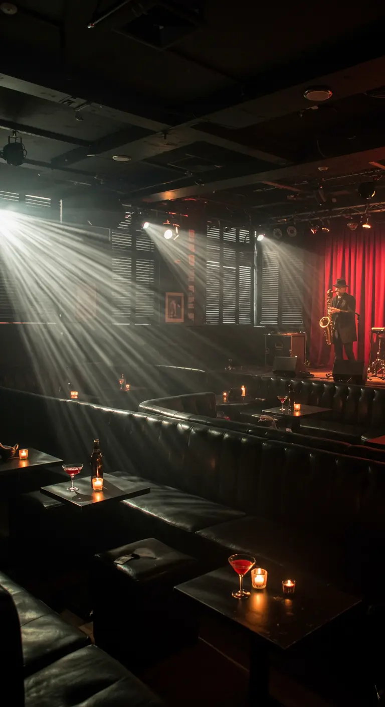 Club de jazz sombre éclairé par des spots, avec un saxophoniste sur scène.